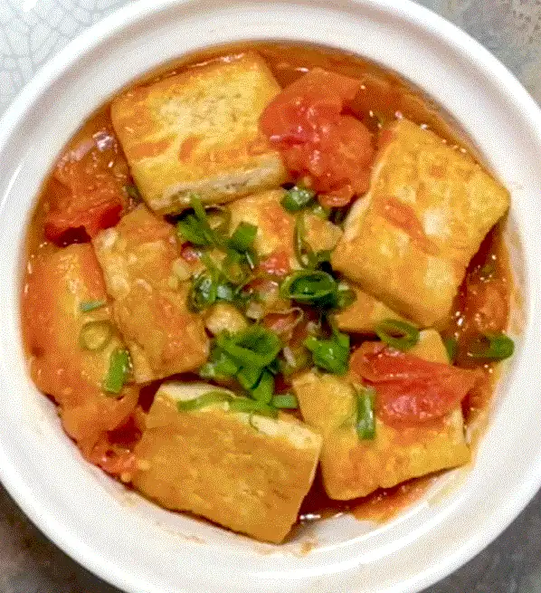 Estofado de tofu y tomate con especias aromáticas, un plato nutritivo a base de plantas, ideal para la cocina ayurvédica.